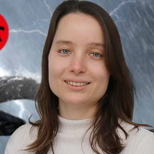 Auf dem Bild sieht man die aktuelle Content Managerin Digital in weißem Oberteil vor einem Hintergrund mit Stier im Gewitter und dem PREFA-Logo in der linken oberen Bildecke..