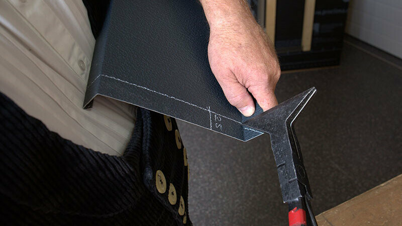 PREFA-Techniker Tom Weiß kantet die Aluminium-Platte entlang der vorher gezogenen Risse mithilfe einer Quetschfaltenzange nach hinten. 