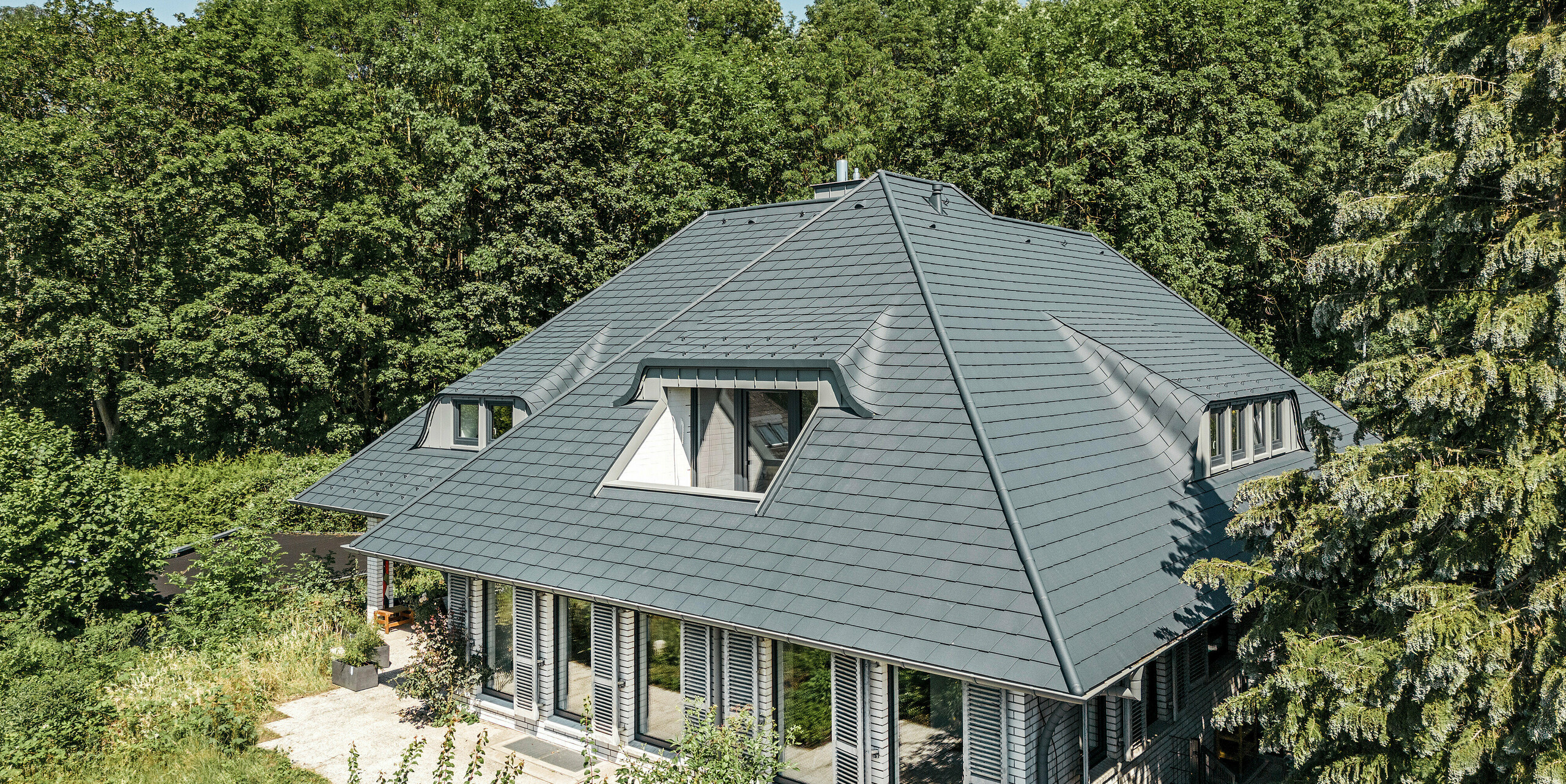 Einfamilienhaus mit spektakulärer Dachlandschaft eingedeckt mit PREFA Dachschindeln in P.10 Anthrazit