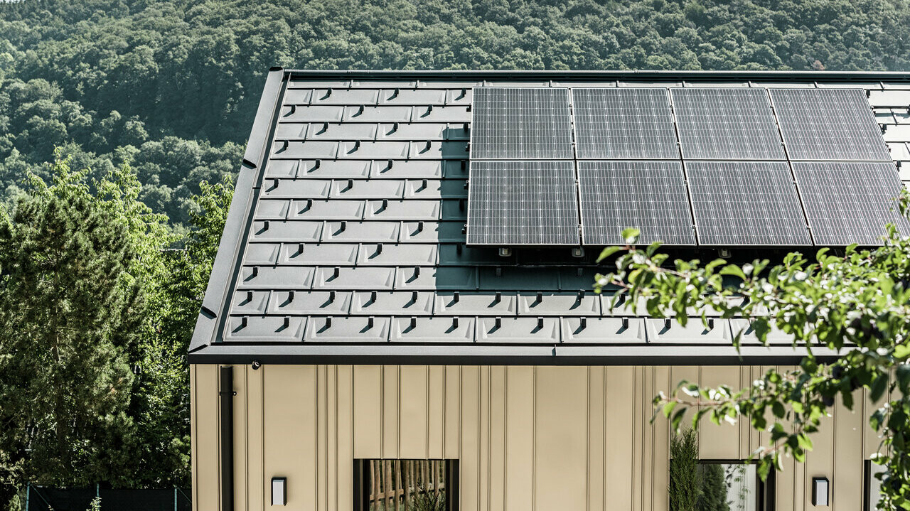 Blick auf ein Einfamilienhaus gedeckt mit der DS.19 mit dem PREFA Solarmontagesystem.