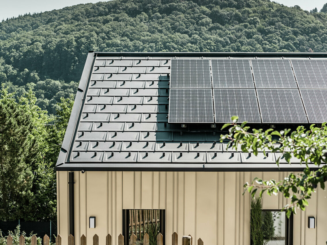 Blick auf ein Einfamilienhaus gedeckt mit der DS.19 mit dem PREFA Solarmontagesystem.