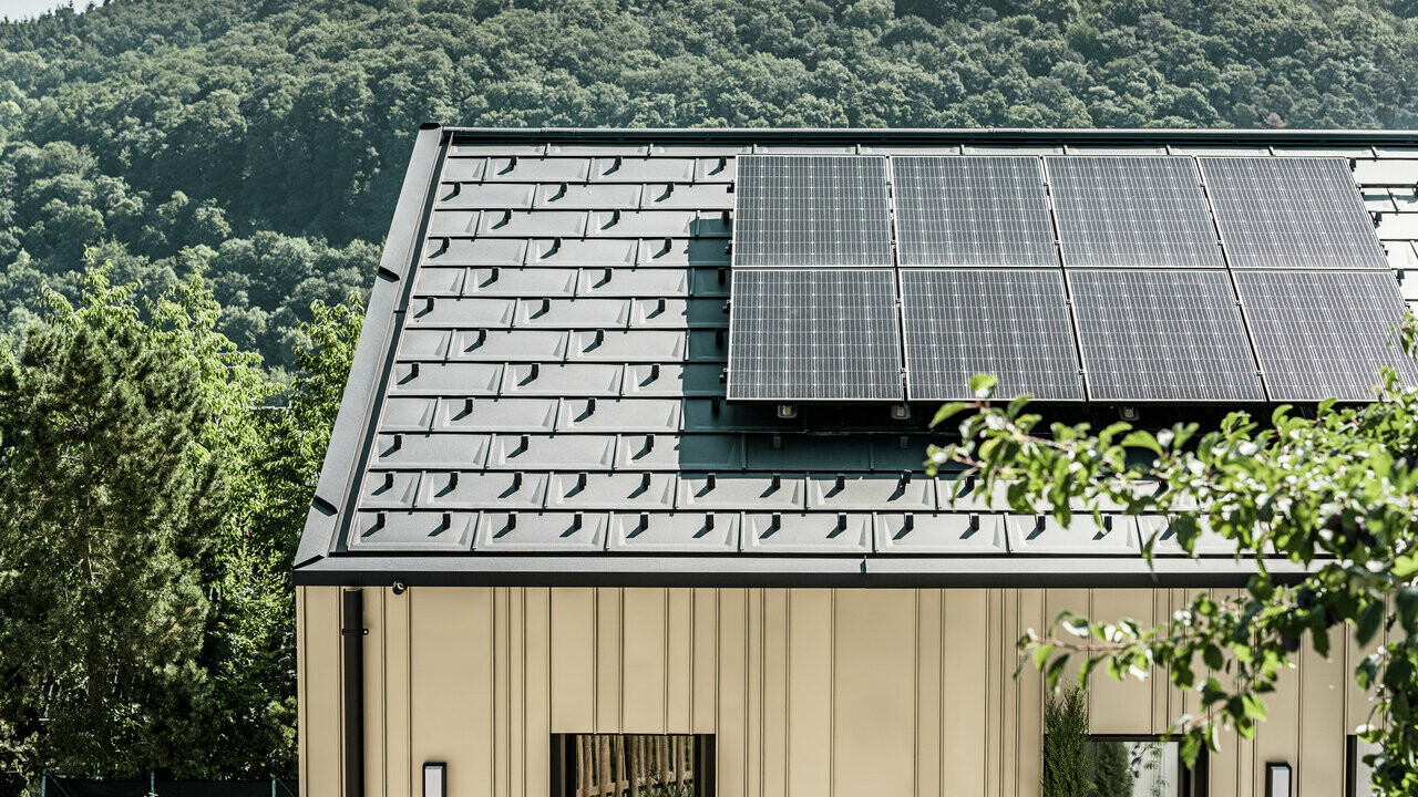 Blick auf ein Einfamilienhaus gedeckt mit der DS.19 mit dem PREFA Solarmontagesystem.