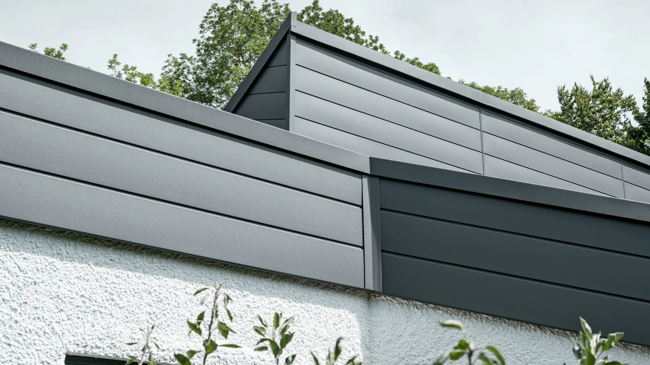 Ein Einfamilienhaus, das mit PREFA Dachschindeln DS.19 in schwarz eingedeckt wurde. Für Teile der Fassade wurden PREFA Sidings in P.10 dunkelgrau verwendet. 