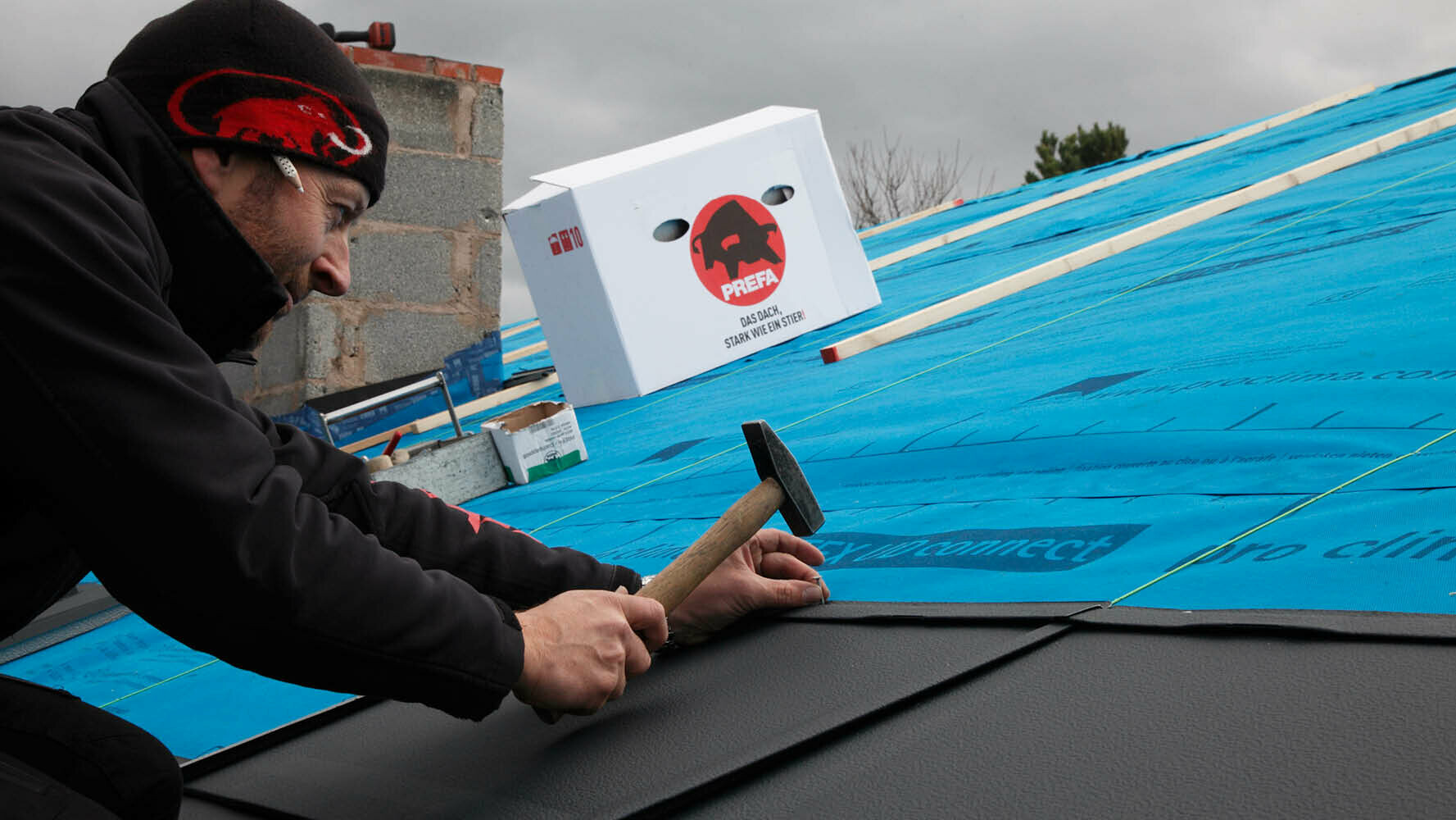 Spenglermeister Jens Scheu befestigt eine PREFA R.16 Dachplatte