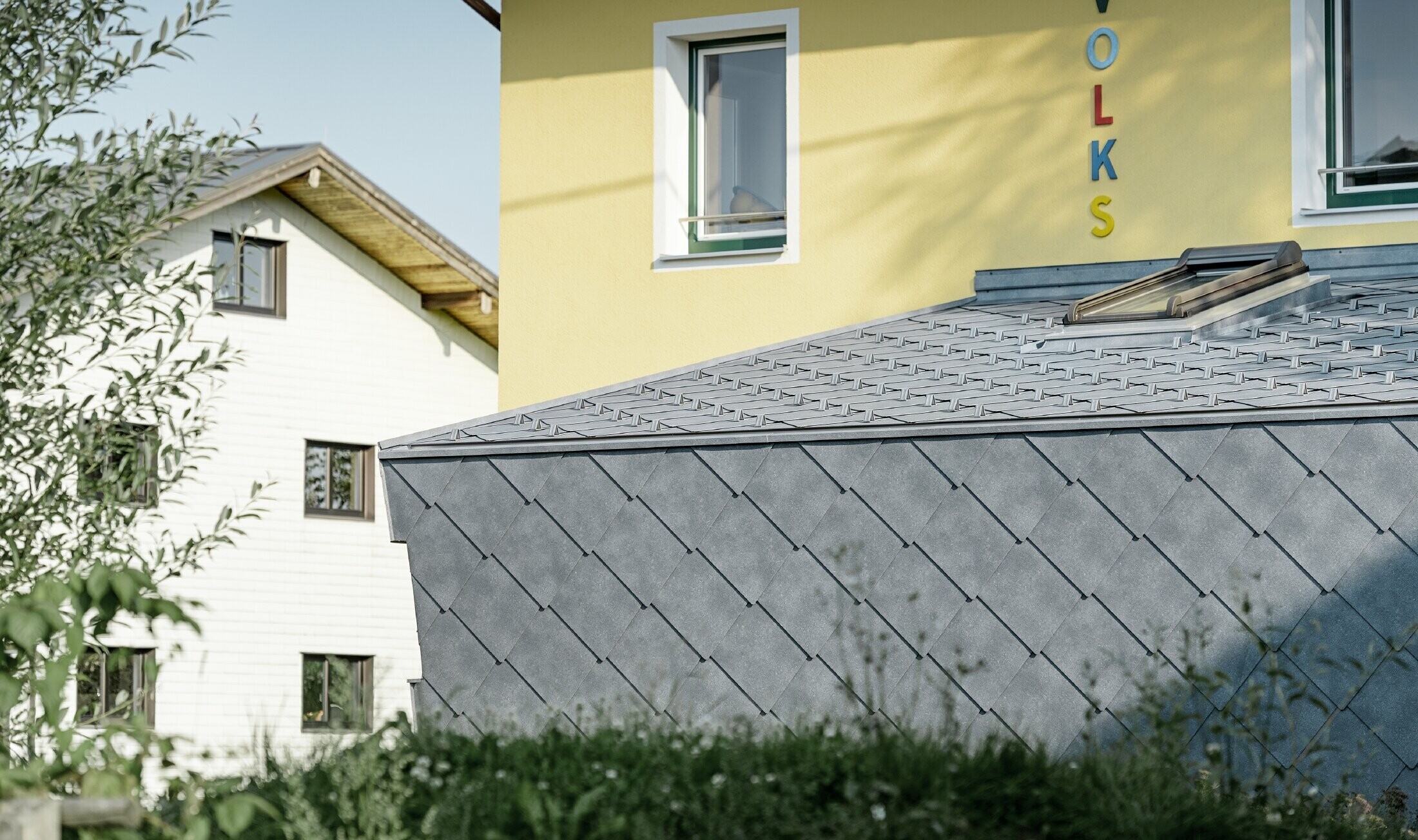 Zubau einer Volksschule eingedeckt mit der Dach- und Wandraute aus Aluminium von PREFA in steingrau