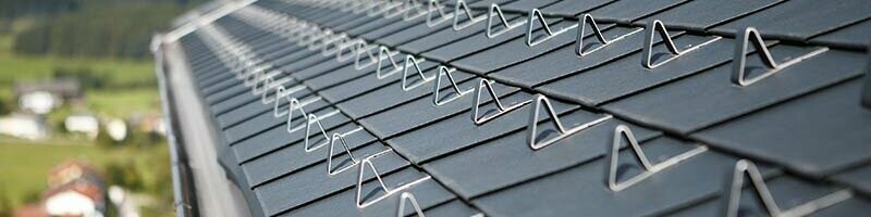 Detailaufnahme der PREFA Dachschindel in Anthrazit mit den PREFA Schneestoppern für den fachgerechten Schneeschutz