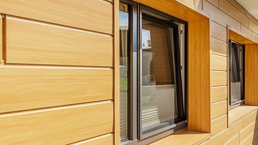 Fassadenverkleidung mit Aluminium Paneelen mit PREFA Sidings in Holzoptik Eiche natur; Wetterbeständige Fensterleibungen in Eiche natur.