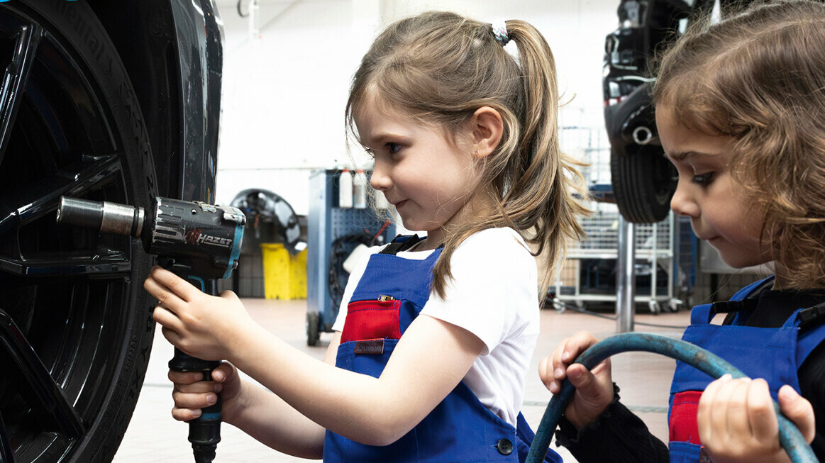 Zwei Mädchen im Kindergartenalter versuchen sich in einem handwerklichen Beruf. PREFA sponsert auch im Jahr 2025 den Kita-Wettbewerb "kleine Hände, große Zukunft".