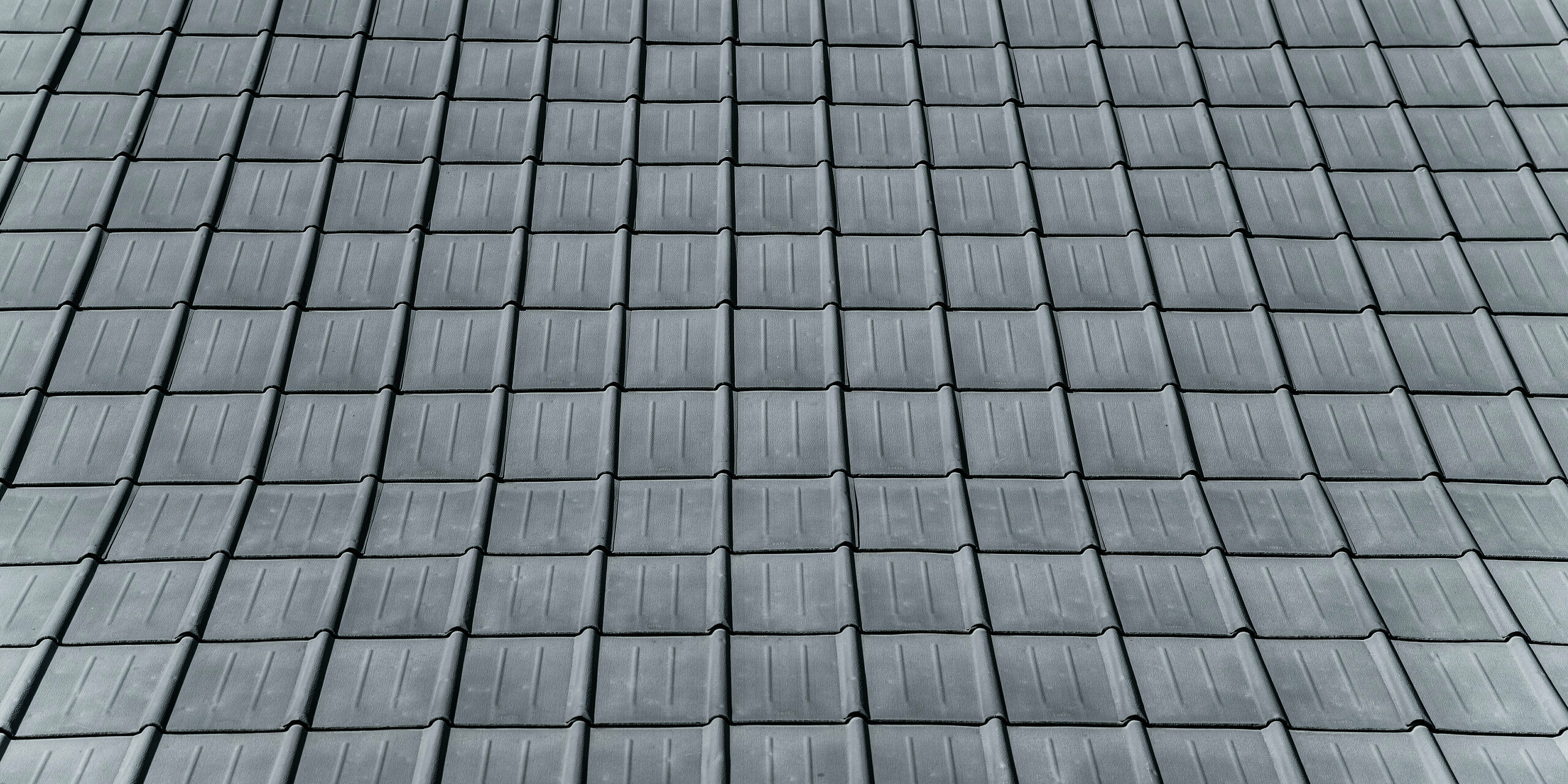 Detailaufnahme des mit robusten PREFA Dachplatten eingedeckten Einfamilienhauses in Tarvis, Italien. Das Bild zeigt das langlebige Aluminiumdach, das seit 1972 zuverlässig den alpinen Witterungsbedingungen trotzt und durch sein zeitloses Design besticht.