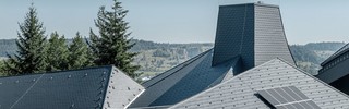 Das verwinkelte Dach der Waldorfschule Heidenheim konnte mit den flexiblen Dachschindeln von PREFA optimal eingedeckt werden