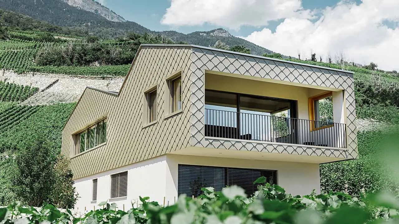 Modernes Einfamilienhaus in den Weinbergen des Rhônetals mit der PREFA Wandraute in Bronze verkleidet mit unterschiedlichen Dachhöhen