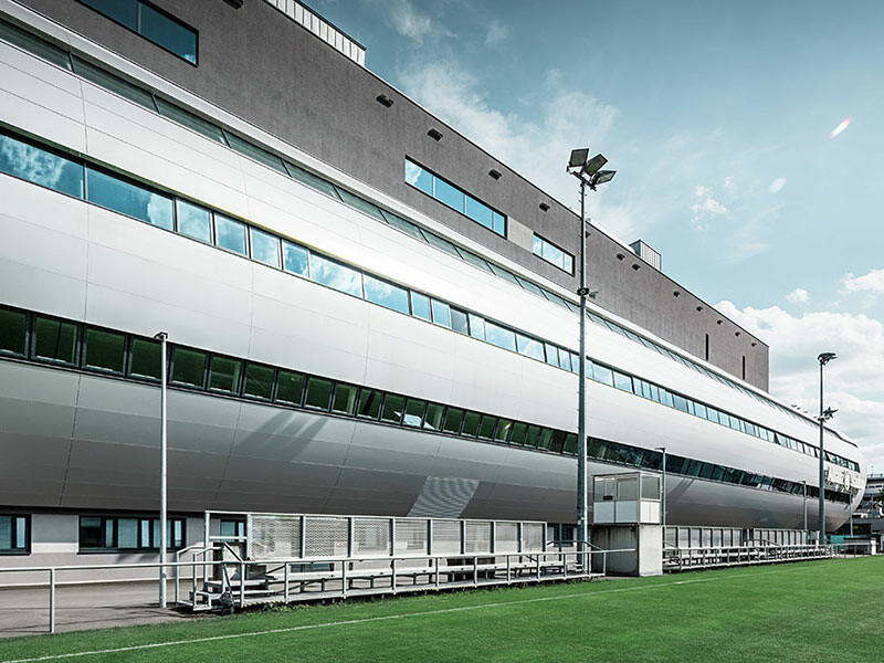 Ansicht des Allianz Stadions in Wien vom Trainingsplatz aus; Die Röhre, die in das Innere des Stadions führt ist mit der PREFA Aluminium Verbundplatte in Silbermetallic verkleidet.
