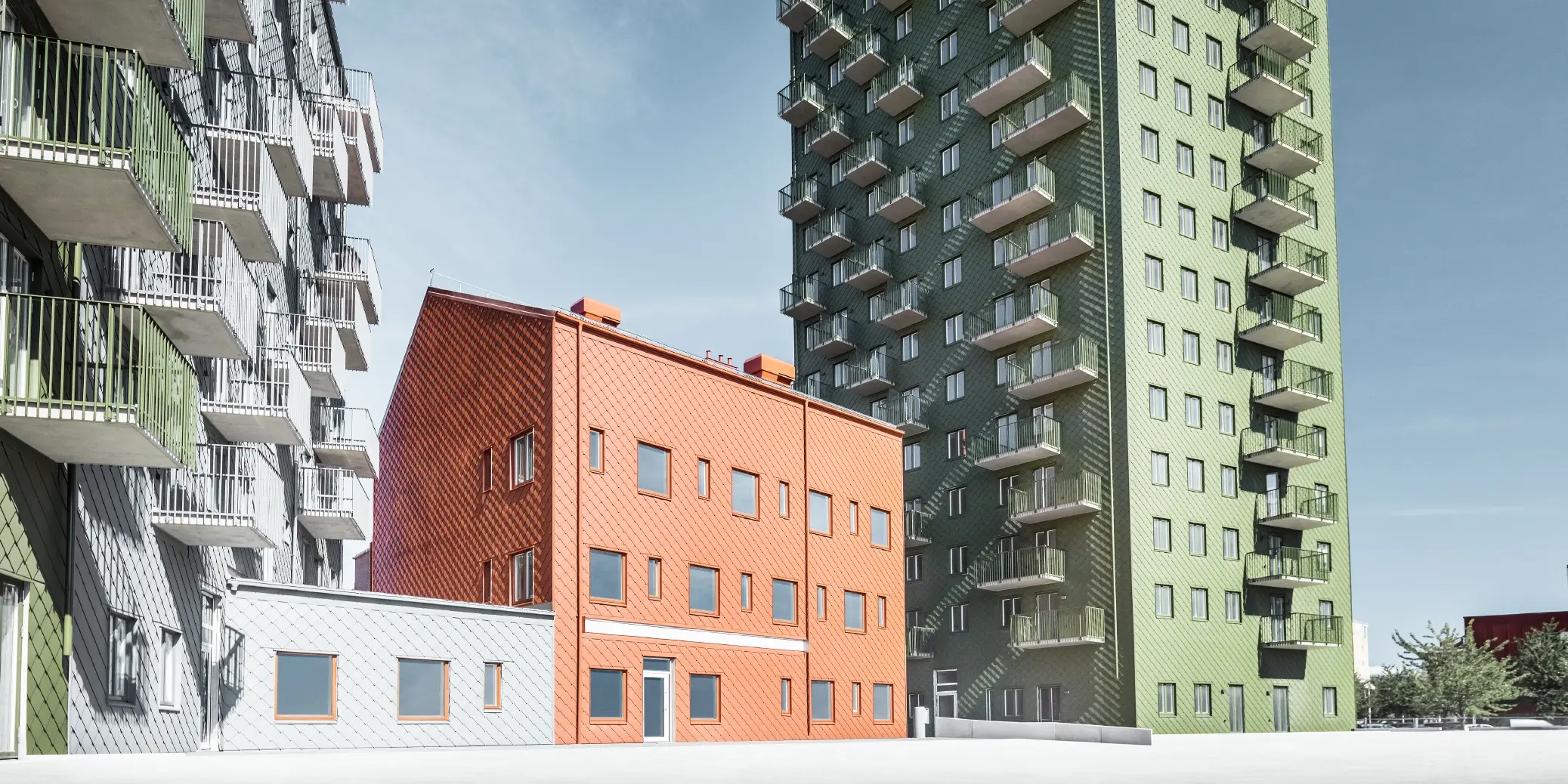Mehrere Wohnbauten verkleidet mit der PREFA Wandraute 29 × 29 in den Farben Olivgrün, Ziegelrot und Hellgrau in Göteborg, Schweden.
