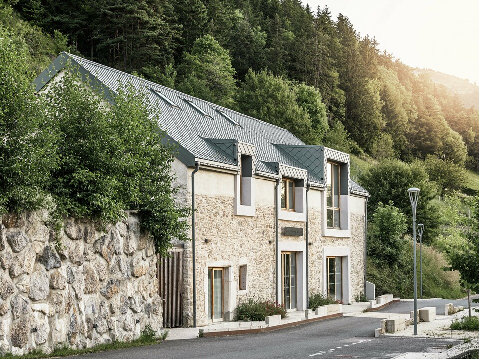 Die restaurierte Scheune "La Grange à Gaby" in Engins, Frankreich. Das Gebäude kombiniert traditionelles Steinemauerwerk mit einem modernen PREFA Aluminiumdach aus 29 × 29 cm großen Rauten. Die Sanierung verbindet historische Bauweise mit zeitgemäßer Architektur und nachhaltigen Materialien.