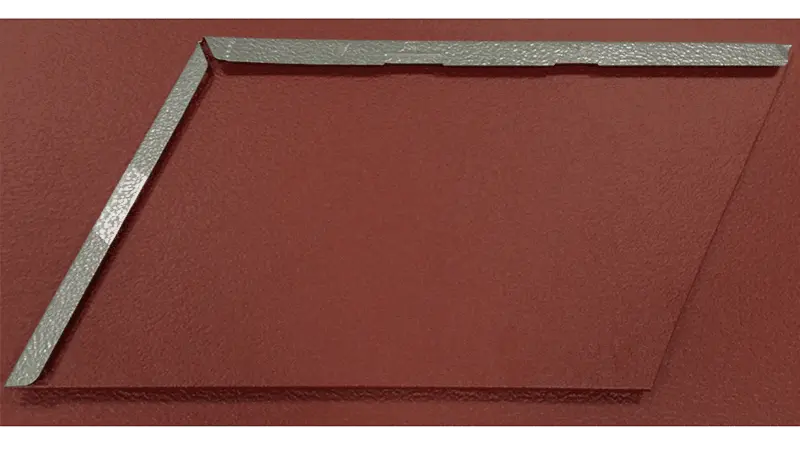 Schritt 1 beim Anfertigen einer Schindelimitation - Zuschnittstreifen werden angefertigt auf einer oxydroten Aluminiumplatte