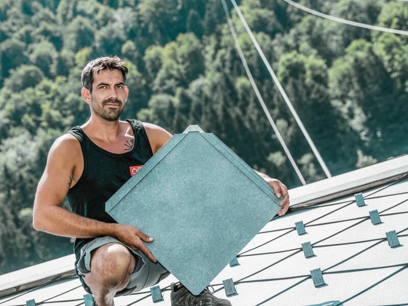 Verarbeiter Anton Ulrich präsentiert auf dem Dach eine Wandraute 44 × 44 in P.10 Steingrau