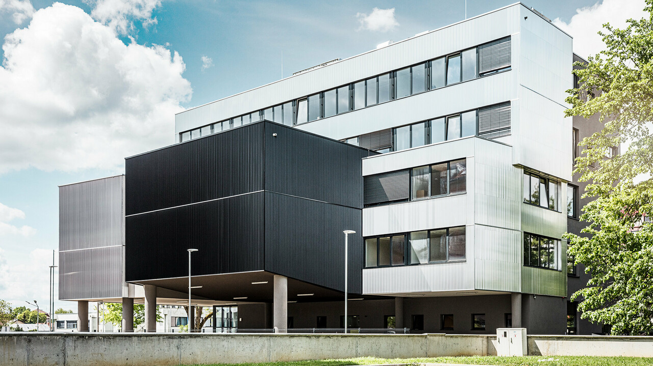 Seitenansicht der Musikschule in Bjevolar mit einer modernen PREFA Fassade im Zackenprofil. Die Fassade ist in Schwarz und aluminiumblank gehalten, und die geometrischen Formen sorgen für ein markantes, minimalistisches Design.