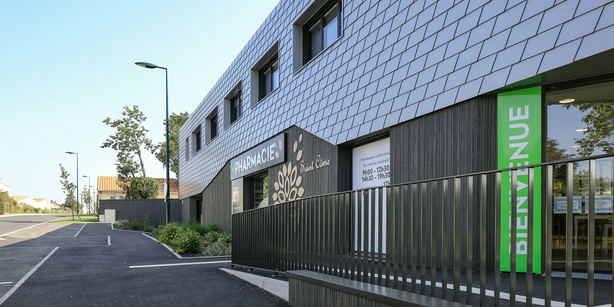 Detailaufnahme der Apotheke in Le Landreau mit einer Fassade aus PREFA Wandschindeln in Silbermetallic