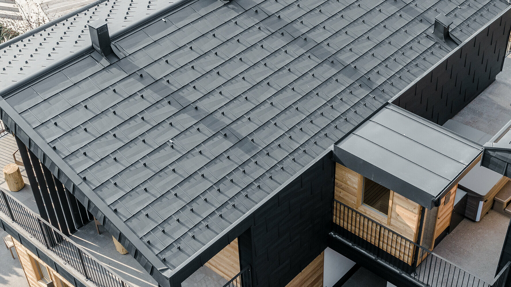 Neue Apartments mit PREFA Dachpaneel und Fassadenpaneel FX.12 in P.10 Anthrazit und Holz verkleidet.