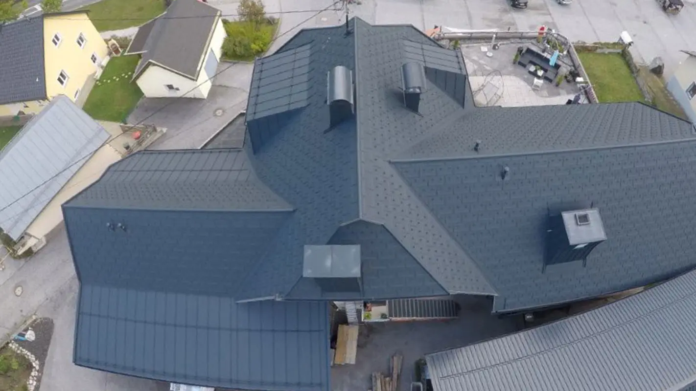 Dachsanierung einer großen Dachfläche mit vielen Details - Kehlen, Gauben und Kamine. Das Dach ist mit der Alu Dachplatte R.16 von PREFA in Anthrazit eingedeckt.