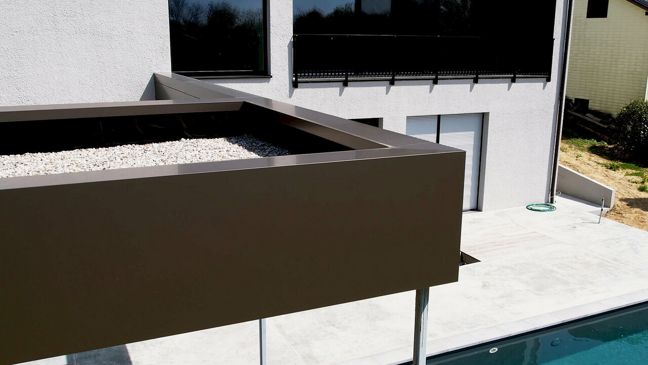 Ansicht der Sonderlösung der Poolüberdachung, wobei die Fassade über die Attika gekantet ist.