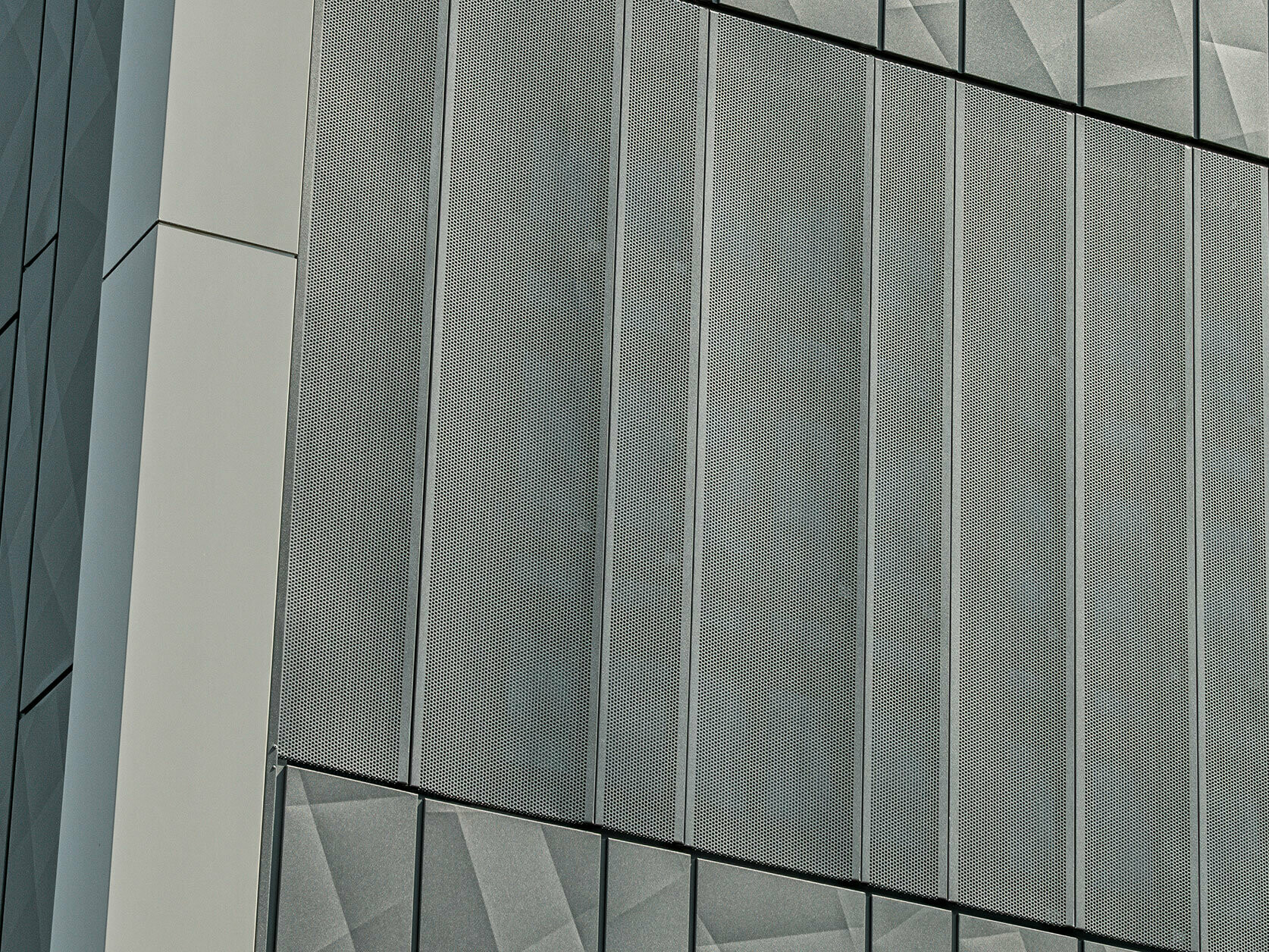 Fassadenansicht eines Eurospar-Markts in Rohrbach mit PREFA Siding.X und perforierten Sidings in der Farbe Anthrazit. Die Siding.X-Elemente zeigen ein lebendiges, geometrisches Fugenbild, während die perforierten Sidings eine moderne, luftdurchlässige Struktur bieten.