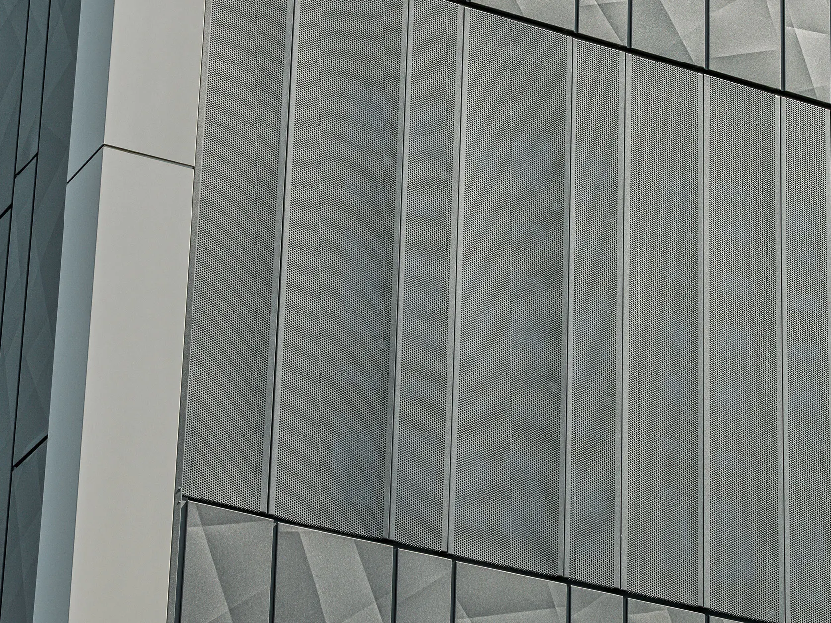 Fassadenansicht eines Eurospar-Markts in Rohrbach mit PREFA Siding.X und perforierten Sidings in der Farbe Anthrazit. Die Siding.X-Elemente zeigen ein lebendiges, geometrisches Fugenbild, während die perforierten Sidings eine moderne, luftdurchlässige Struktur bieten.