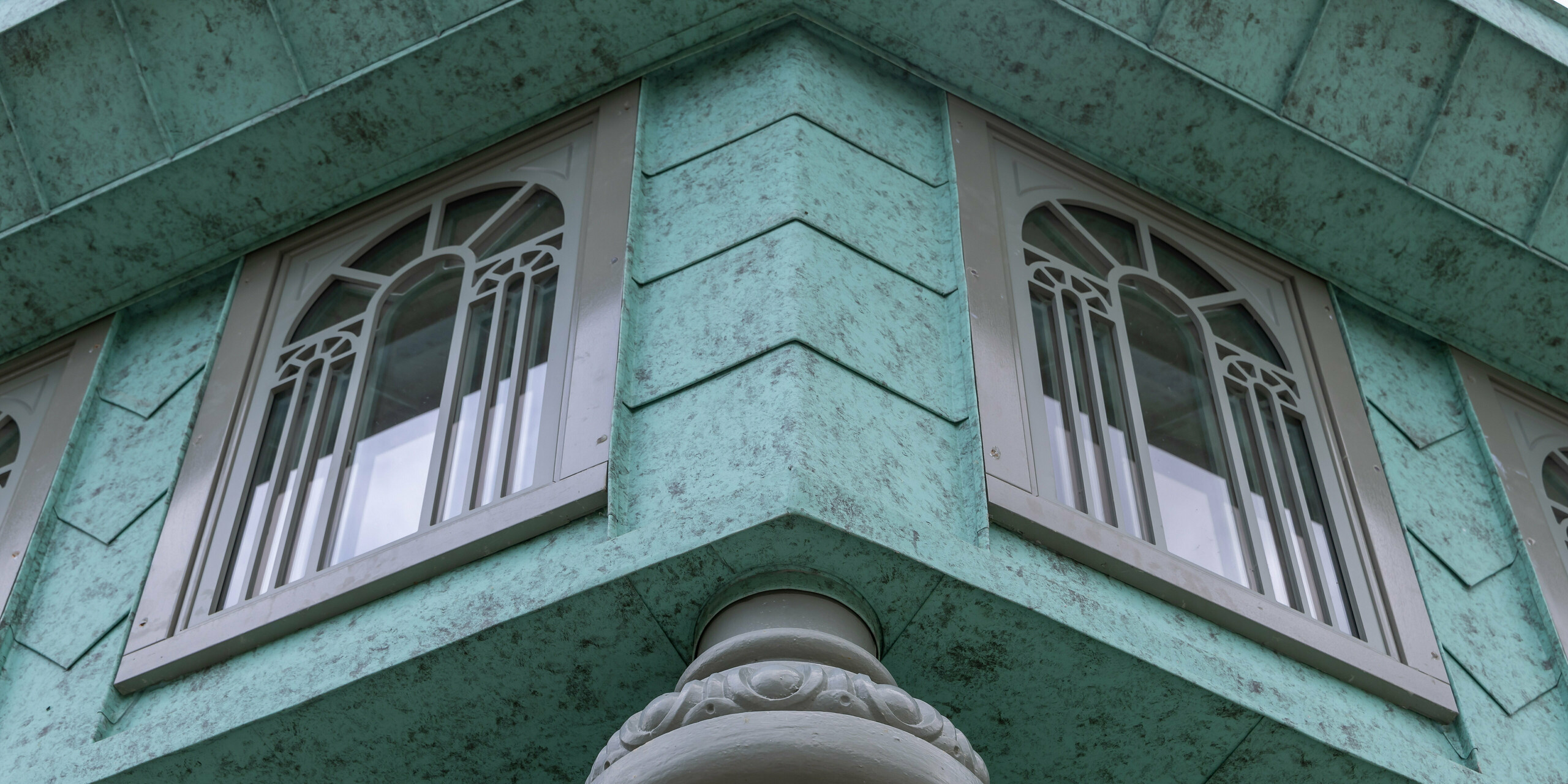 Nahaufnahme eines Gartenhauses mit einer PREFALZ-Fassade in P.10 Patinagrün