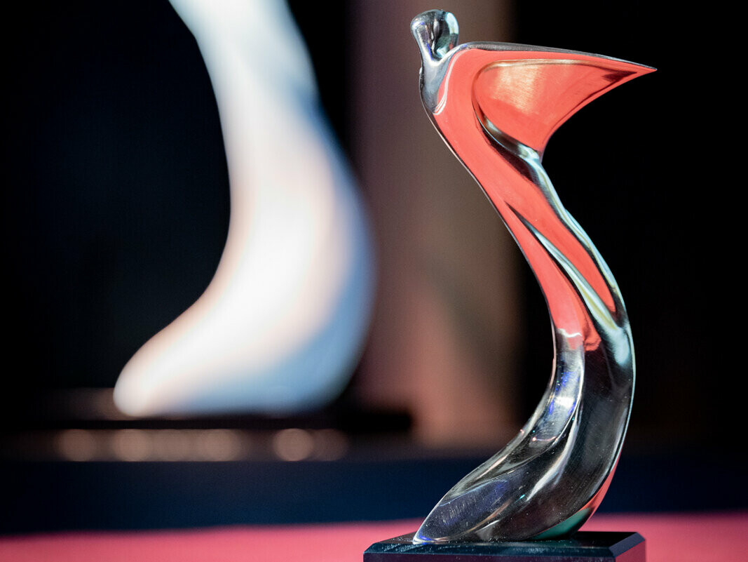 Detailaufnahme der silbernen Trophäe des Architects' Darling Awards 2023, welche auf der Bühne mit rotem Teppich steht.