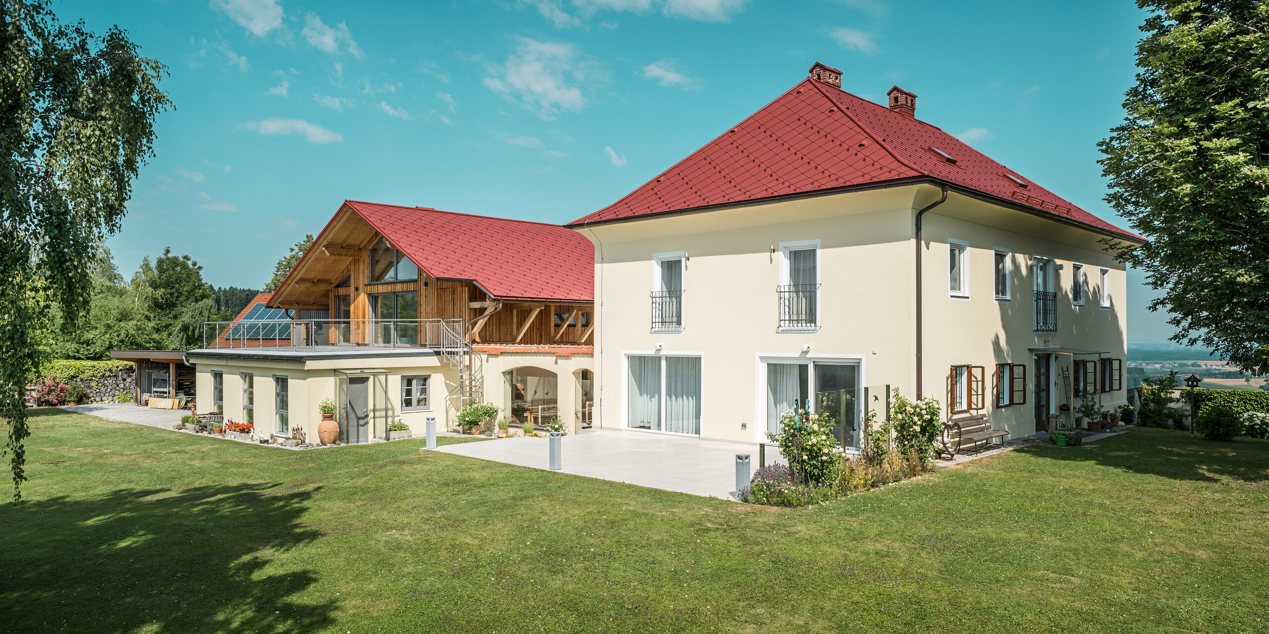 Die sanierten Einfamilienhäuser in Aschach an der Steyr wurden mit der auffälligen PREFA Dachraute 44 x 44 in der Farbe P.10 Oxydrot eingedeckt. Die rote Farbe setzt markante Akzente, während die Kombination aus traditioneller Fassade und modernem Dach für eine harmonische und elegante Wirkung sorgt.