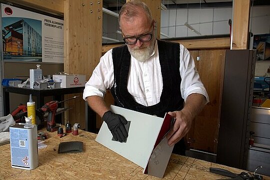 Tom Weiß schleift und reinigt die Unterseite einer Aluminiumverbundplatte
