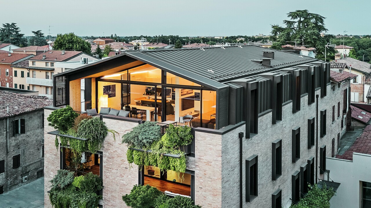 Nachhaltiges Wohnhaus in Italien mit PREFALZ-Aluminiumdach und grüner Ziegelfassade.
