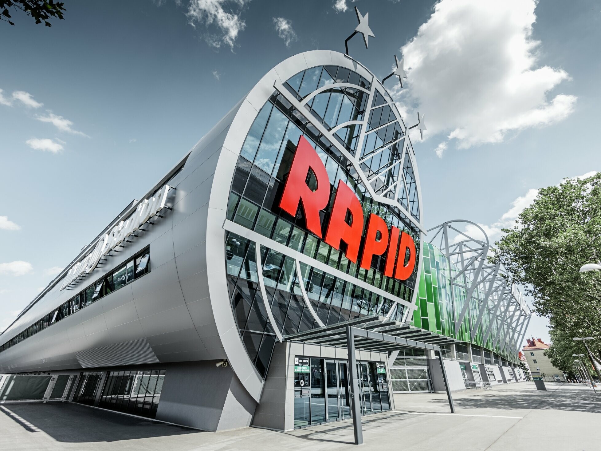 Der Eingang ins Allianz Stadion mit dem großen SK Rapid Wien Logo; Die Röhre mit der großen Glasfront ist mit der PREFA Aluminium Verbundplatte in Silbermetallic eingedeckt.