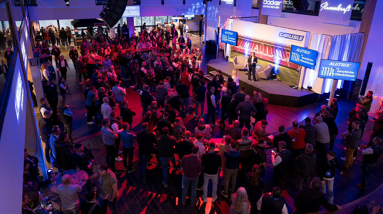 Großer Besucherandrang bei einer Produktpräsentation auf der Bühne des Carlisle Branchenevents in der Mainz Arena. Teilnehmer verfolgen die Vorstellung von Neuheiten, begleitet von Carlisle-Branding, LED-Screens und professioneller Eventbeleuchtung.