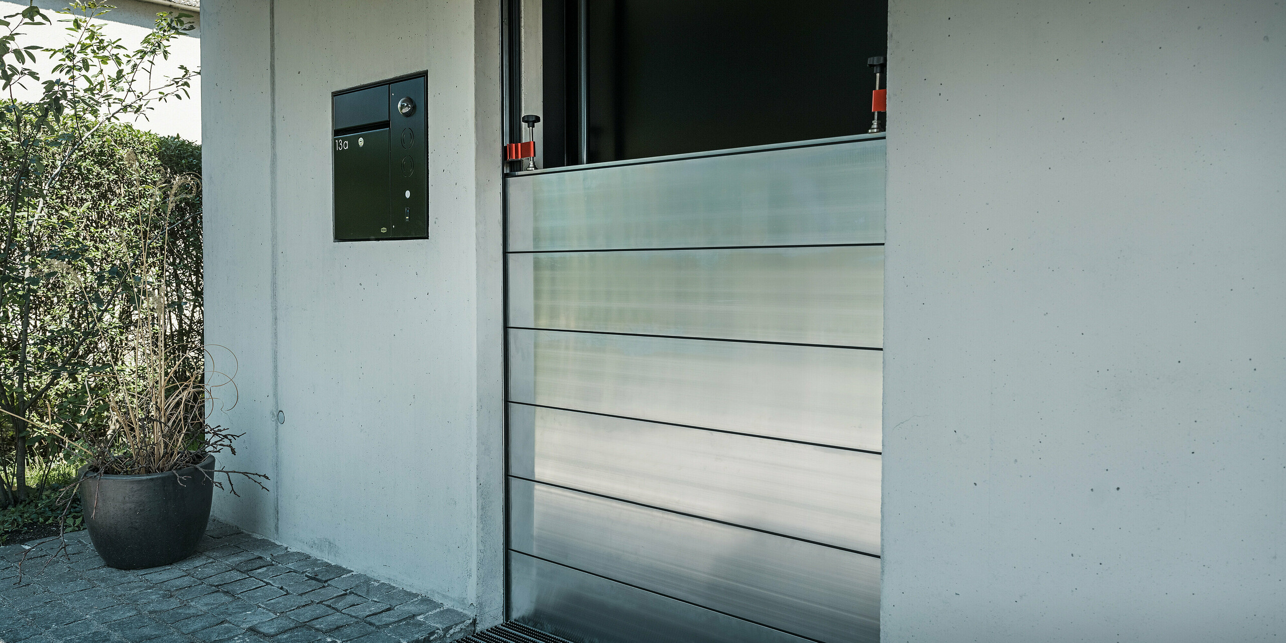 Komplettmontage des PREFA Hochwasserschutzes an der Eingangstüre eines Einfamilienhauses in Lustenau. Die formschöne Integration der Aluminiumprofile schützt das Gebäude im Ernstfall vor Hochwasser und sorgt für eine ansprechende Optik.