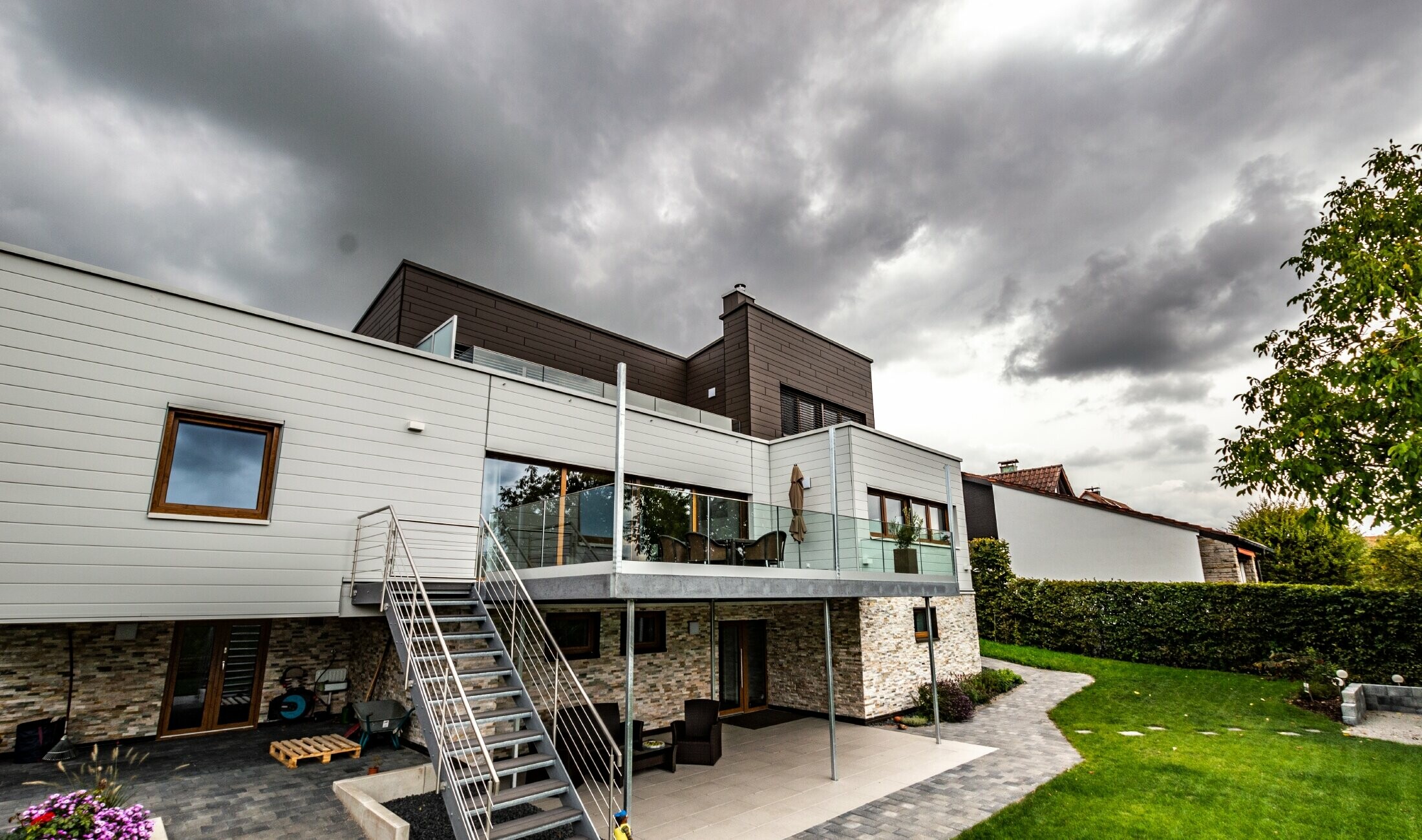 Wohnhaus mit Flachdach und weißer und brauner Fassade mit PREFA Sidings horizontal verlegt.