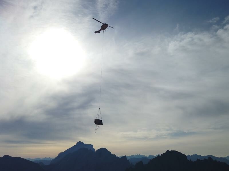 Transport des mobilen Ausstellungspavillons mit dem Hubschrauber zur Totalphütte in Vorarlberg
