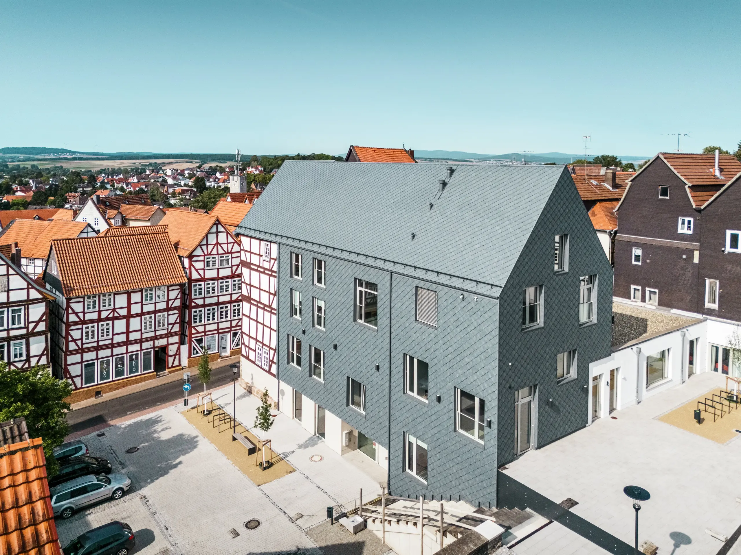 Hochwertige Sanierung des Volkshauses in Homberg, DE, eingebettet in die historische Altstadt mit Fachwerkhäusern. Dach, Giebel und große Teile der Fassade sind mit robusten und eleganten PREFA Aluminium-Rauten 29 × 29 in P.10 Steingrau eingedeckt. Die schuppenartige Aluminiumdeckung ist langlebig, farbbeständig und fügt sich perfekt in die geschichtsträchtige Umgebung ein.
