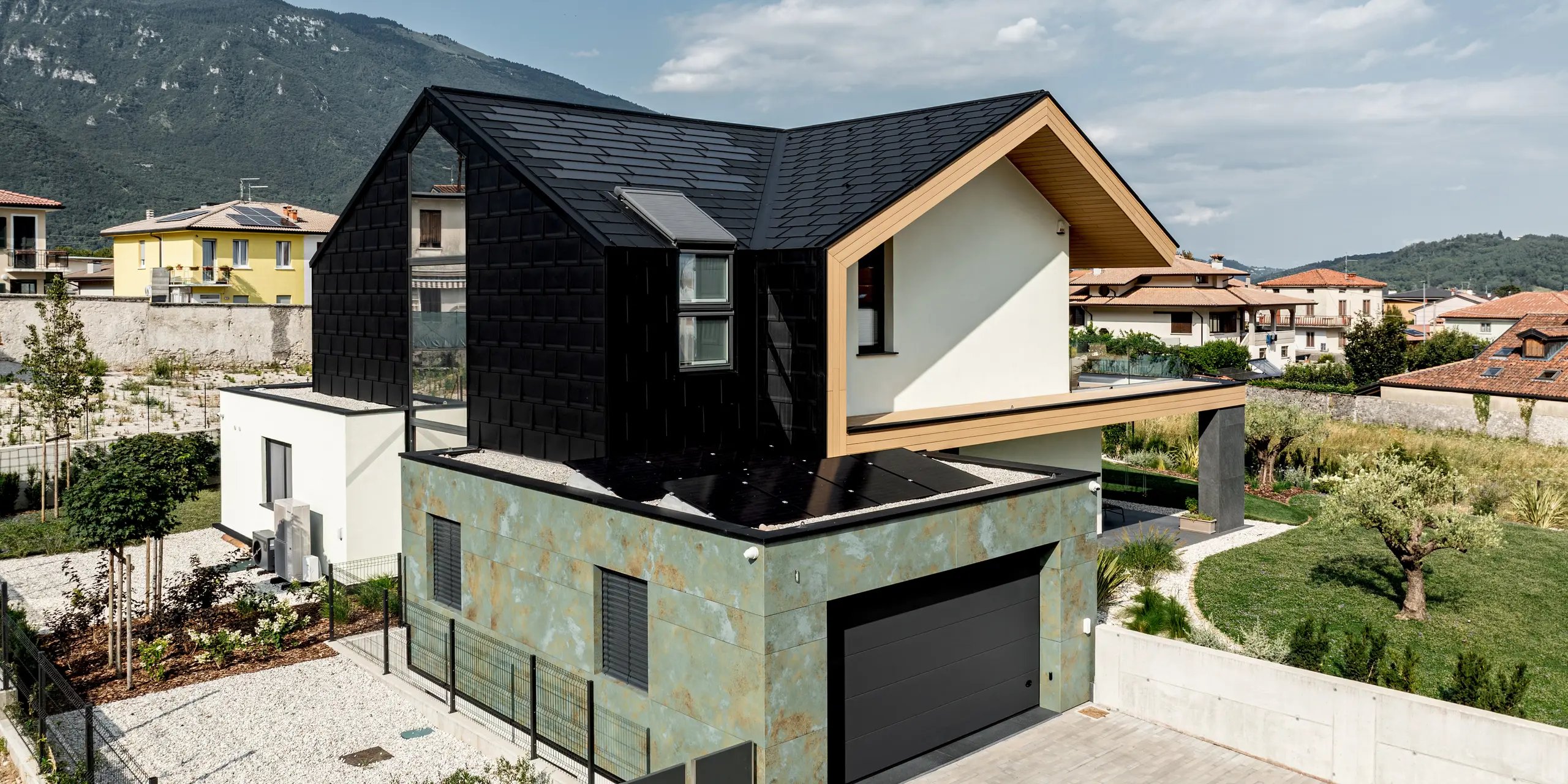 Architektonisches Einfamilienhaus in Vicenza mit markanter PREFA Dachplatte R.16 an Dach und Fassade in P.10 Schwarz. Die klare Linienführung der Aluminiumverkleidung setzt einen modernen Kontrast zur natürlichen Umgebung. Das robuste PREFA Aluminium überzeugt durch Langlebigkeit, geringes Gewicht und zuverlässigen Schutz vor Witterung – ein stilvoller Blickfang.