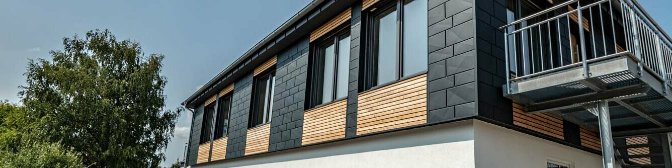 Firmengebäude mit anthrazitfarbener Fassade mit PREFA Siding.X Paneelen