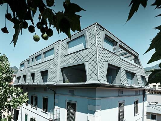 Aufstockung eines Italienischen Penthouses mit der modernen Dacheindeckung aus Aluminium von PREFA in Hellgrau mit großen Fensterauslässen
