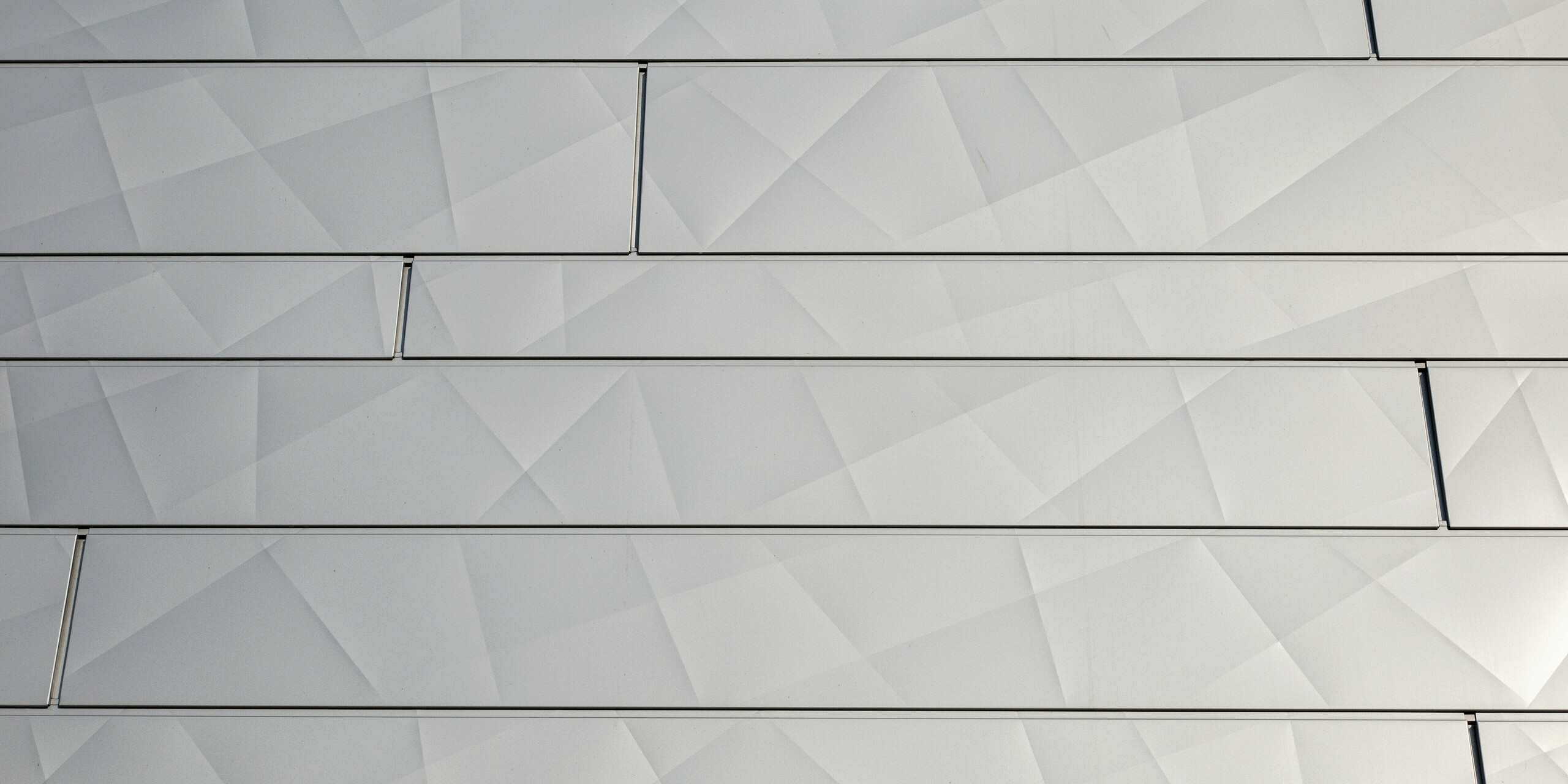 Detailansicht der glitzernden PREFA Siding.X Fassadenpaneele in Silbermetallic am Optik- und Akustik-Shop AFFLELOU in Auray, Frankreich