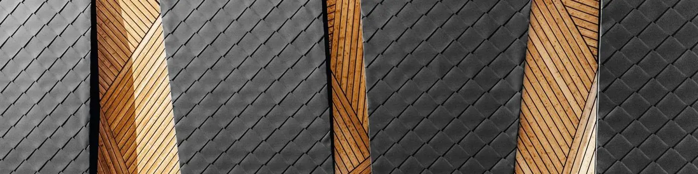 Nahaufnahme der PREFA Wandrauten 44 x 44 in einer modernen Kombination mit Holz.
