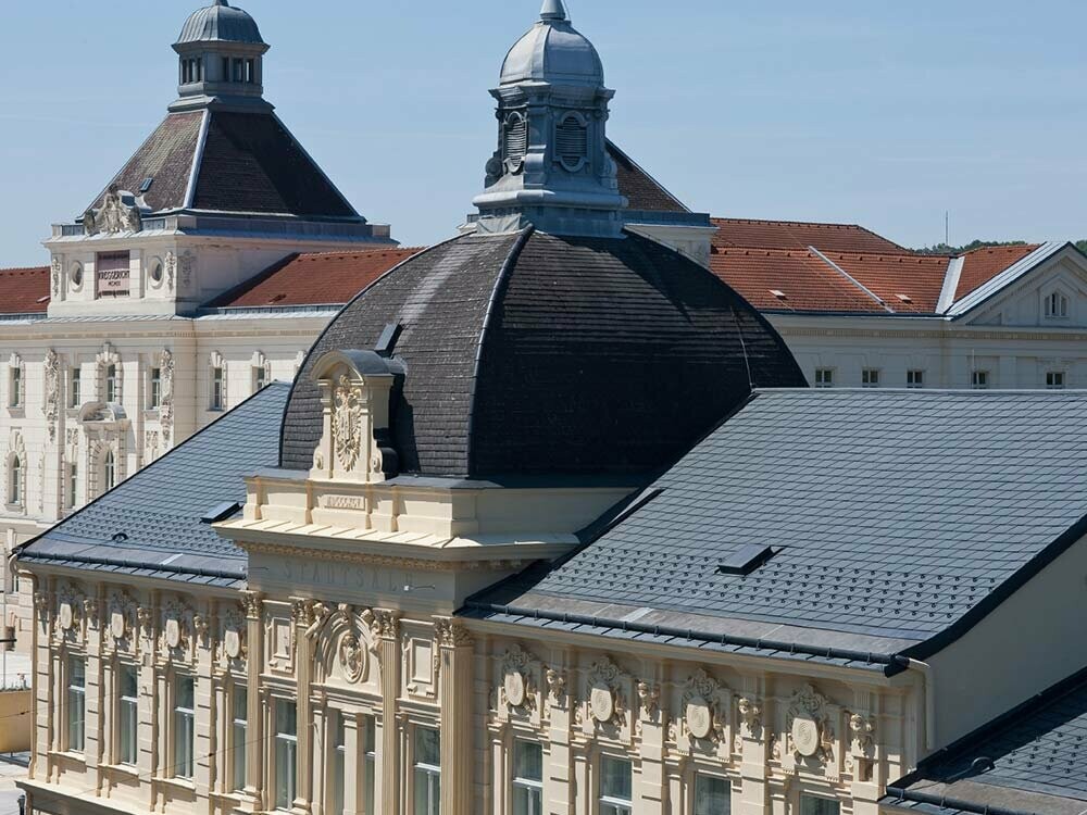Dach der Stadtsäle St. Pölten nach der Sanierung mit PREFA Dachschindeln in Anthrazit
