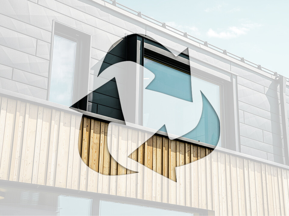 Foto zeigt das Recycling-Symbol vor einer Hausfassade mit PREFA Aluminium-Elementen und Holzpaneelen.