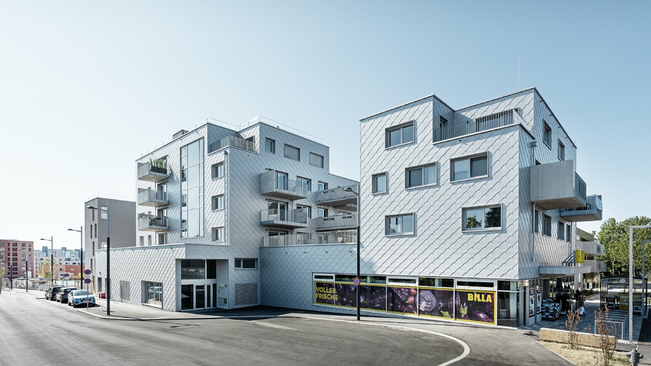 Wohnhausanlagen mit Flachdach und Rautenverkleidung an der Fassade mit der PREFA Wandraute 44 × 44 in Silbermetallic
