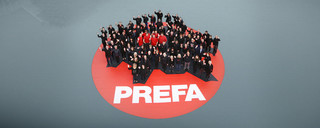 Vogelperspektive von PREFA Mitarbeitern auf einem roten PREFA Logo