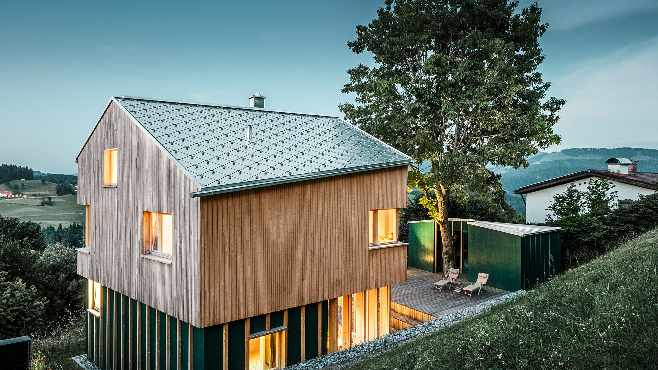Neugebautes Einfamilienhaus mit Holzfassade und naturblankem PREFA Dach in Rautenform