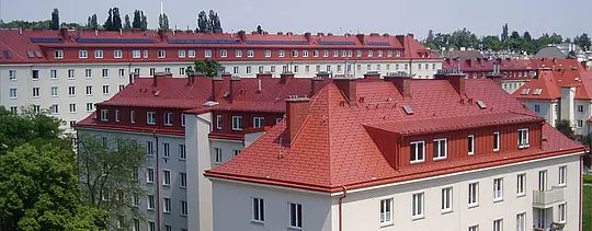 Aufnahme der Wohnhäuser des Hugo Breitner Hofs in Wien. Die Dächer wurden mit der PREFA Dachschindel in Ziegelrot eingedeckt.