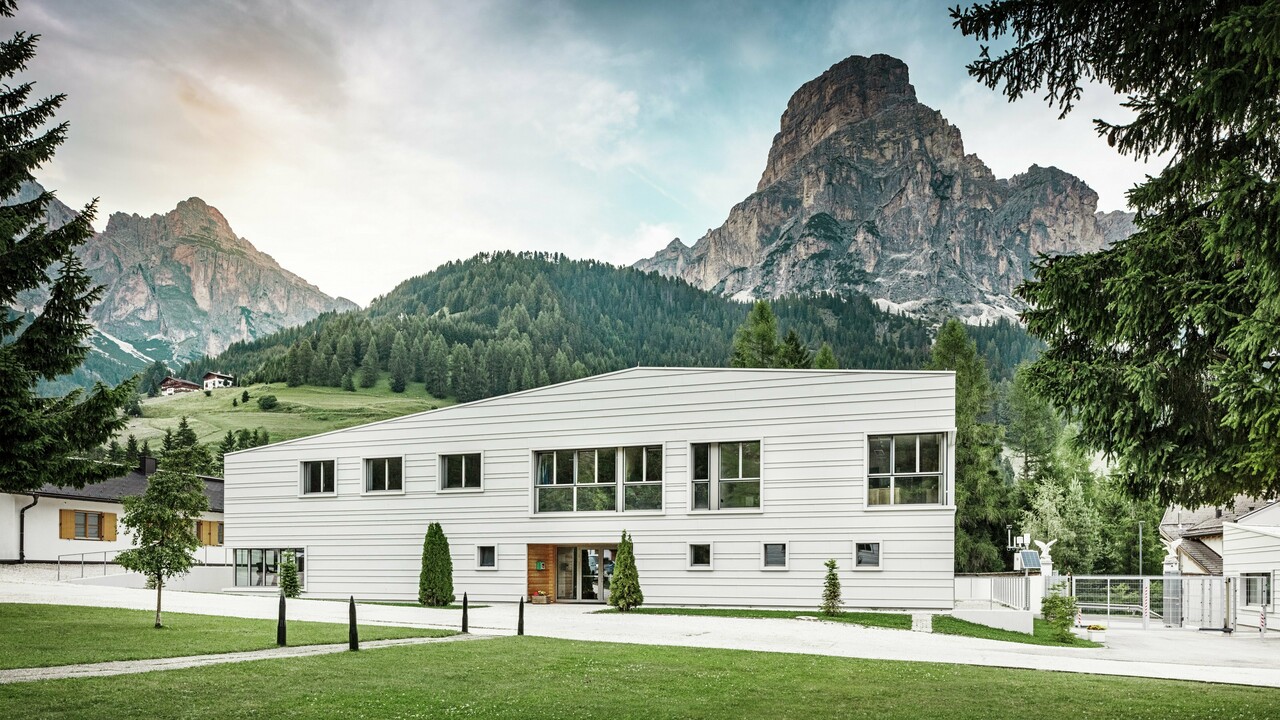 Moderne Militärarchitektur trifft auf alpine Landschaft: Die Kaserne „Tempesti“ liegt inmitten der Südtiroler Landschaft vor einer imposanten Bergkulisse. Die helle PREFALZ-Fassade in der Farbe P.10 Prefaweiß setzt klare Linien. Das helle Aluminium reflektiert das Sonnenlicht und verbessert das Raumklima.